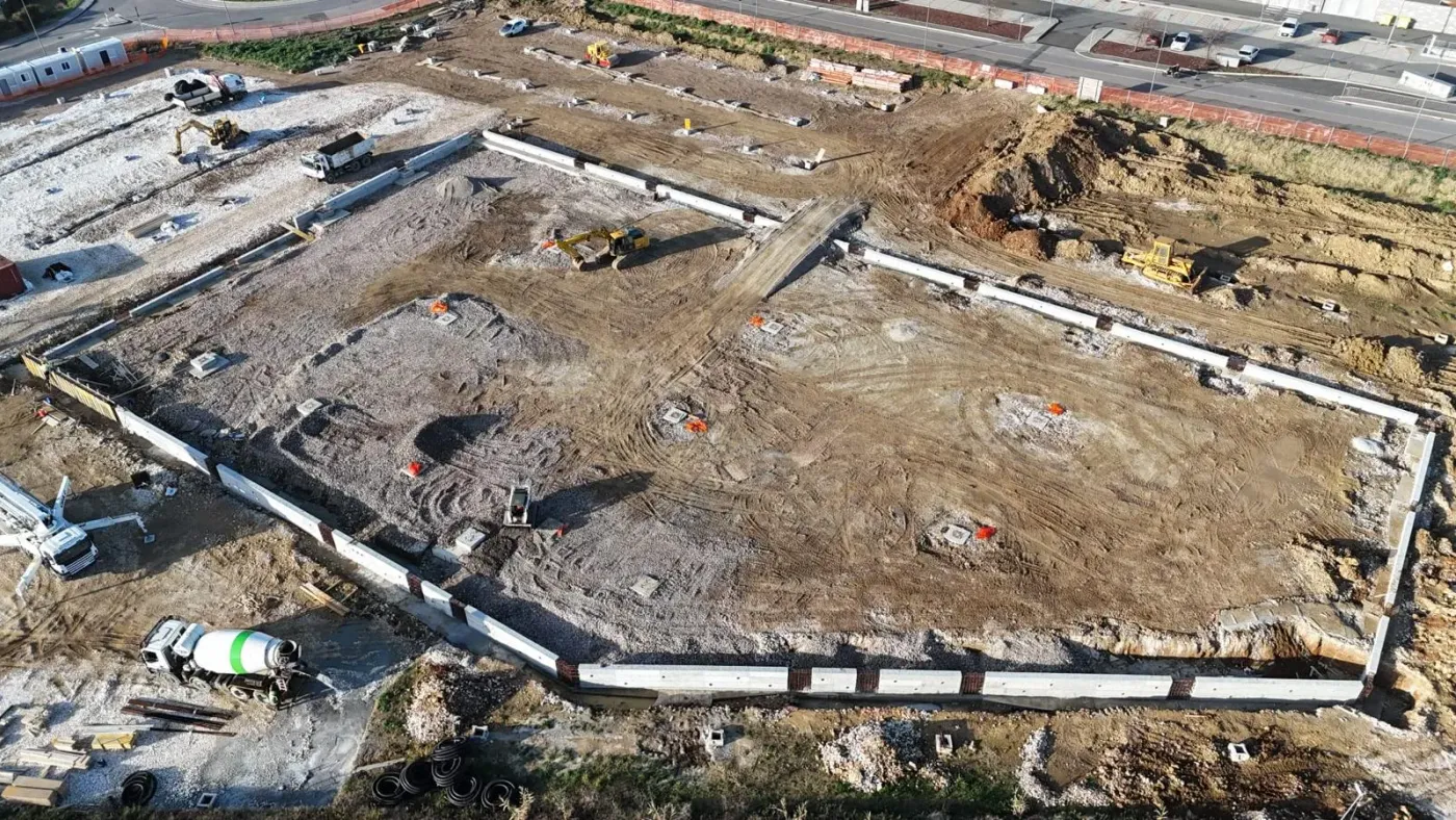 Fondazioni perimetrali viste dall’alto con mezzi al lavoro.
