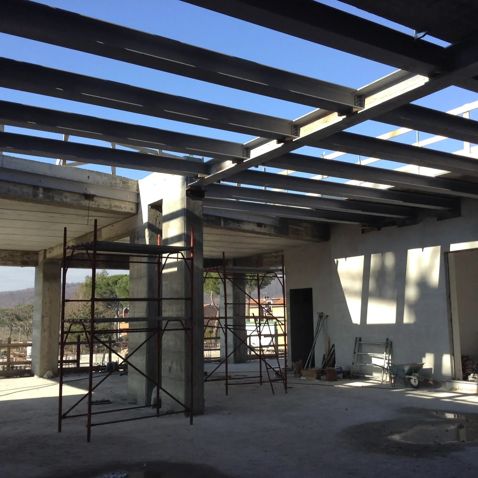 Interno del piano in costruzione con pilastri, travi e trabattello.